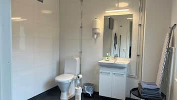 Un baño moderno con inodoro, lavamanos y espejo.