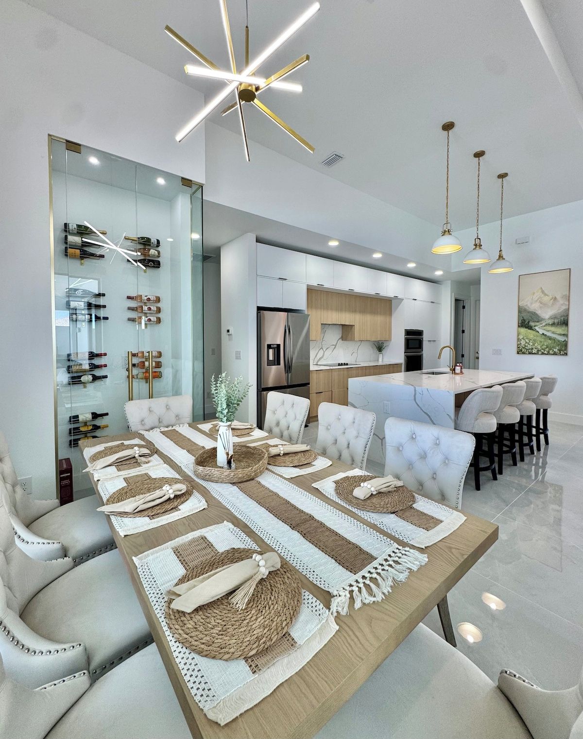 A modern kitchen with a central island, stainless steel appliances, and pendant lighting.