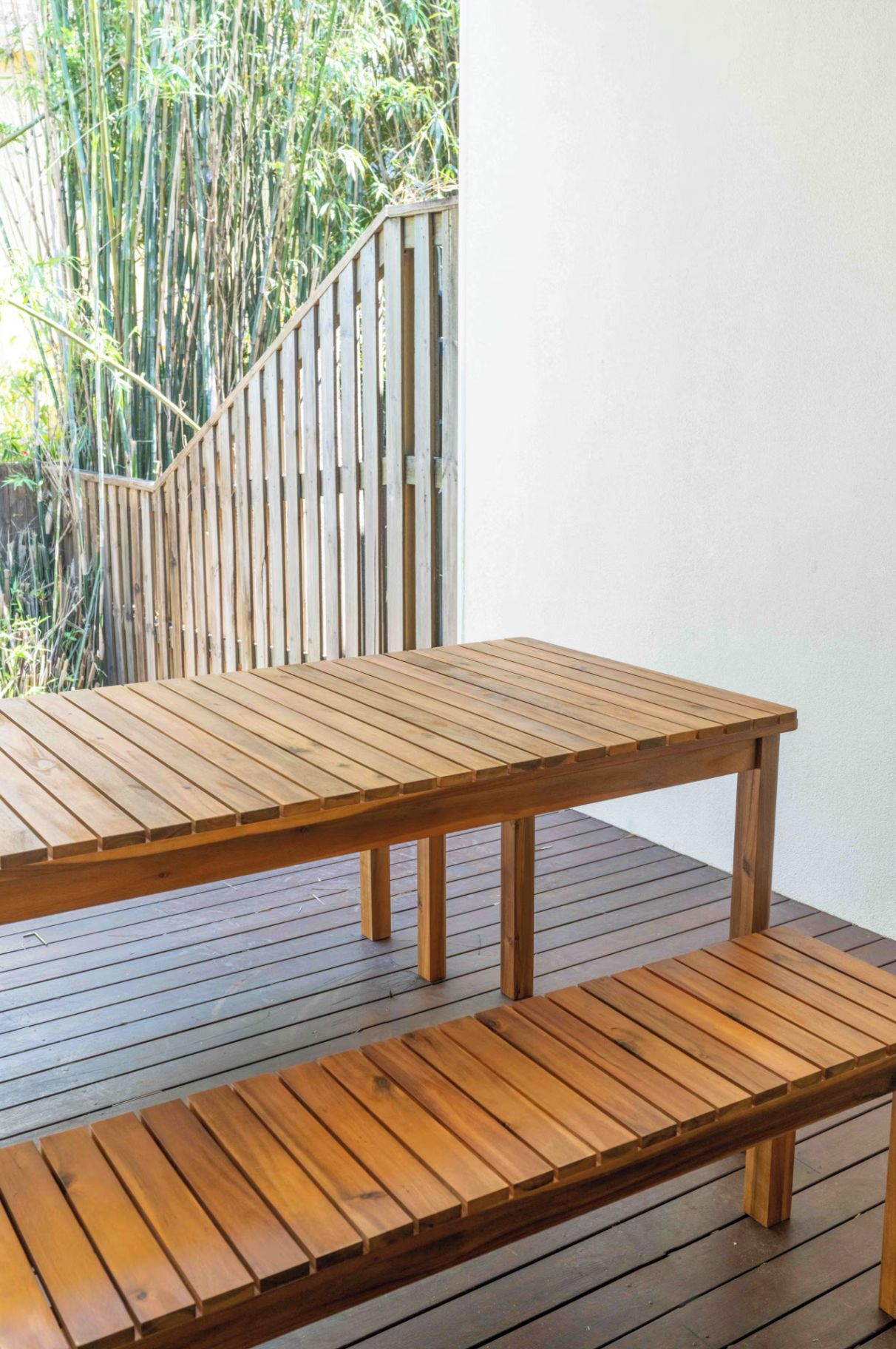 A wooden deck with a table and bench.