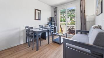 Un salon moderne comprenant un coin repas, un canapé et un téléviseur.