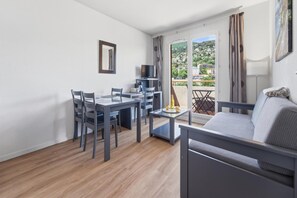 Un salon moderne comprenant un coin repas, un canapé et un téléviseur.