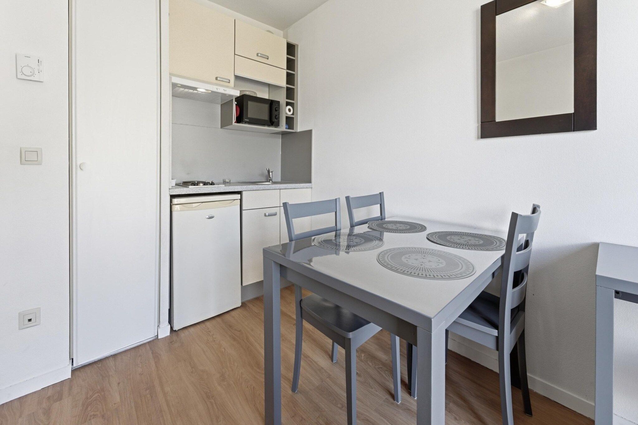 A compact kitchen with a microwave, stove, and dishwasher.