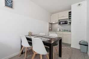 A compact kitchen with a microwave, sink, and cabinets. - Grasse Riviera Apartment with Balcony (Grasse)