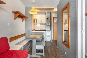 A compact kitchen with white cabinets, a wooden countertop, and a hanging light fixture. - Apartment near Tignes Slopes (Tignes)