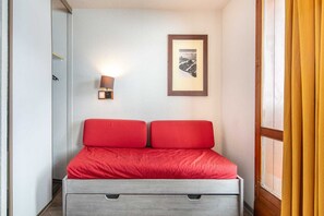 A room with a bed, a wall-mounted light, and a framed picture. - Apartment near Tignes Slopes (Tignes)