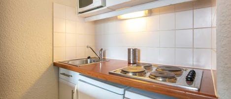 Una kitchenette funcional equipada con microondas, pileta y estufa.