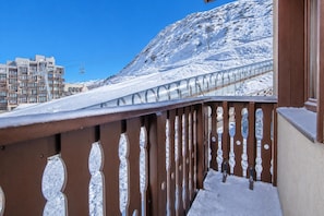 A snow-covered balcony with a metal railing, a clear blue sky, and a mountainous background. - Alpine Ski Apartment in Tignes for 4 (Tignes)