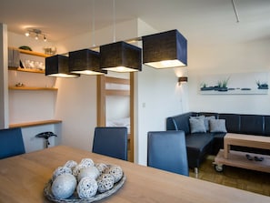 Un espacio moderno para vivir con una mesa de comedor, sillas, sofá y una cama litera.