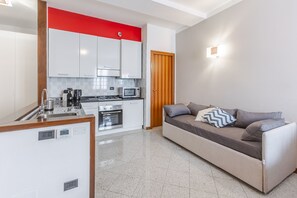 A compact living space with a kitchenette, a sofa, and a dining area. - Le Charme, heart of Verona (Verona)