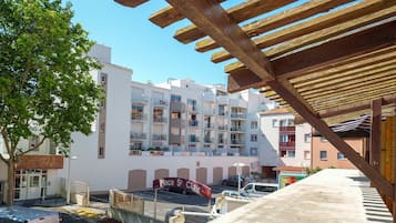 A multi-story building with balconies, a covered outdoor area, and a sign indicating 'Place St Clair.'