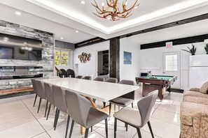 Une cuisine moderne dotée d’une grande table à manger, d’appareils électroménagers intégrés et d’une table de billard.