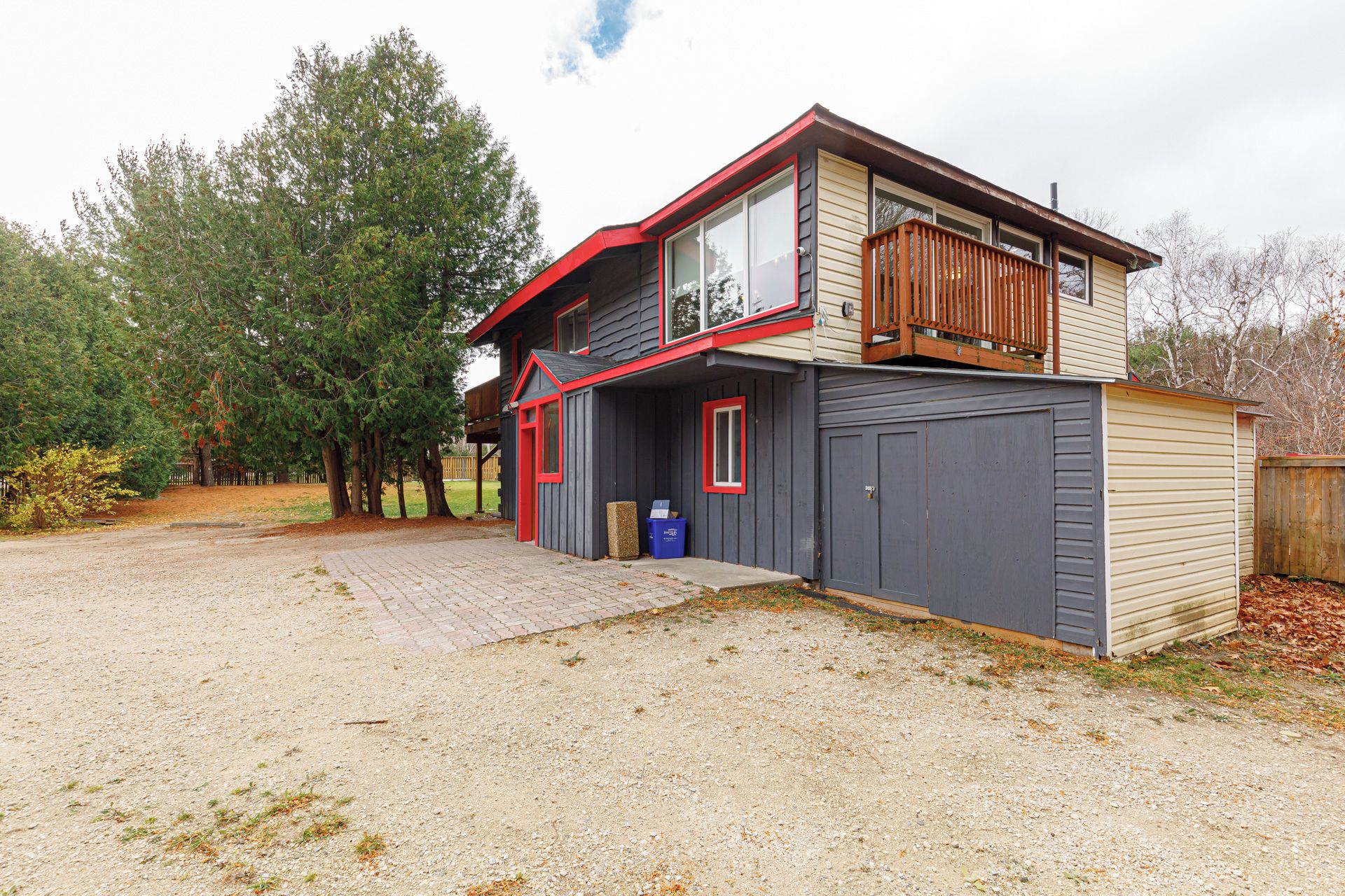 A two-story house with a garage, a covered porch, and a small shed.