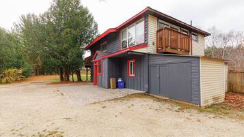 A two-story house with a garage, a covered porch, and a small shed.