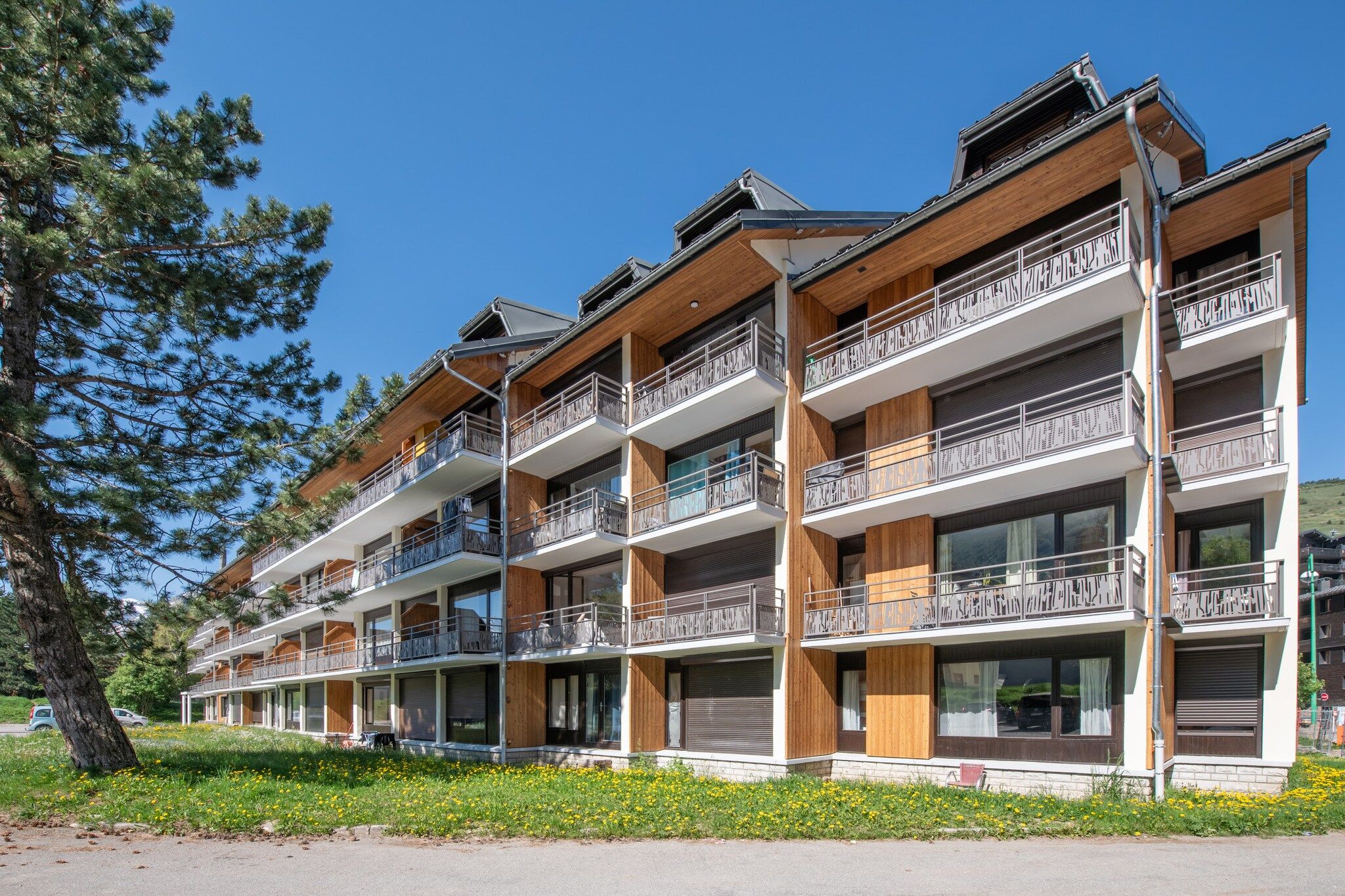 A multi-story hotel with balconies, large windows, and a wooden facade.
