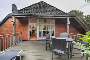 A small house with a brick exterior, a tiled roof, and a covered patio with outdoor furniture. - Idyllic, Quiet Apartment with Wi-Fi (Grebin)