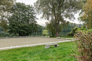 A fenced equestrian arena with a bench, surrounded by trees and a body of water. - Idyllic, Quiet Apartment with Wi-Fi (Grebin)
