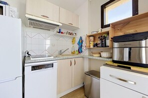 A modern kitchen with white cabinets, a stainless steel refrigerator, and a dishwasher. - Alpine Ski Apartment in Tignes for 4 (Agde)