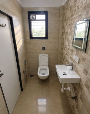 A bathroom with a toilet, sink, and window. - Sea Side Near Arnala beach (Vasai)