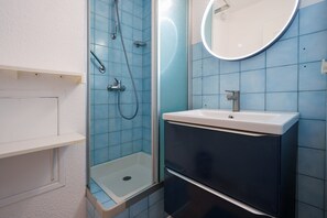 A bathroom with a glass-enclosed shower, a sink, and a mirror. - Family Apartment for 6 in Les Deux Alpes (Le Grau-du-Roi)