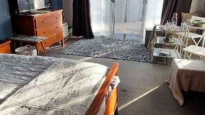 A bedroom with a bed, dresser, and a desk with a chair. - Cozy 1-bedroom apartment in welcoming Cottesloe with AC (Cottesloe)
