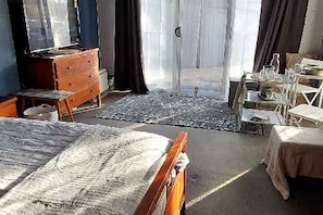 Quarto com cama, cômoda e escrivaninha com cadeira.