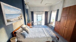 A bedroom with a bed, a wardrobe, a desk, and a chair.