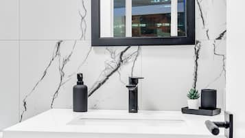 A bathroom with a white marble sink, a black faucet, and a mirror above it.