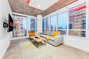 A modern living room with a grey sofa, yellow armchair, and a wooden coffee table.