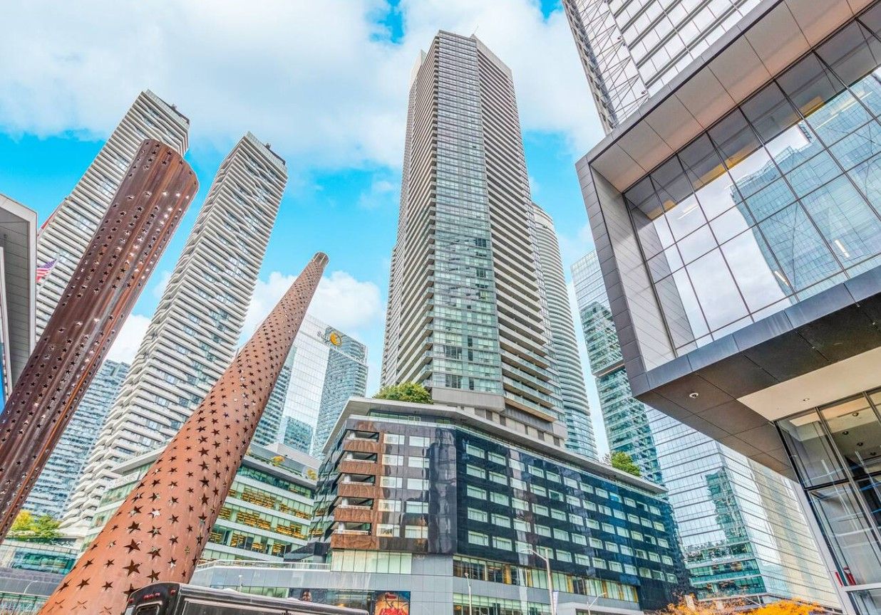 Un paysage urbain avec des immeubles modernes de grande hauteur, dont une structure remarquable aux lignes courbes et ornée de motifs en forme d’étoiles.