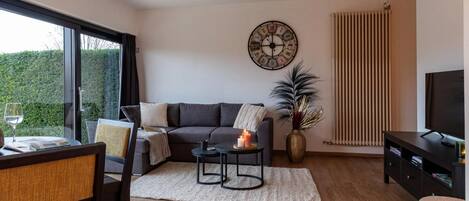 A modern living room with a sofa, coffee table, and a TV.
