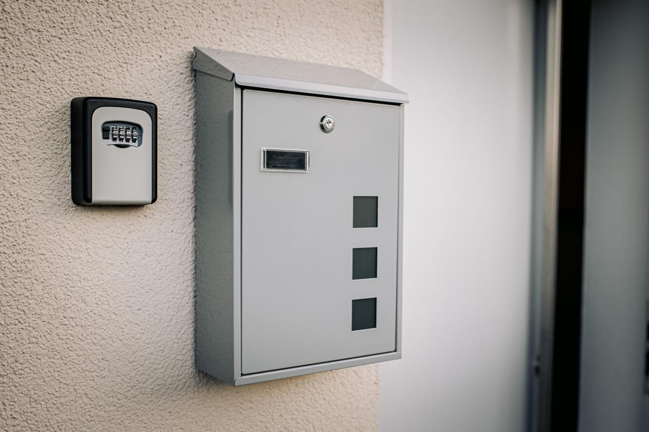 Een grijze beveiligingskast met een keypad aan de muur, waarschijnlijk voor toegangscontrole.