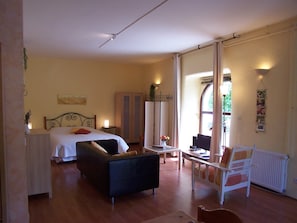 A hotel room with a bed, a desk, a chair, and a radiator. - Gîte "Cigale" with Pool, Minimum Age 18 Years (Beaumont-en-Diois)