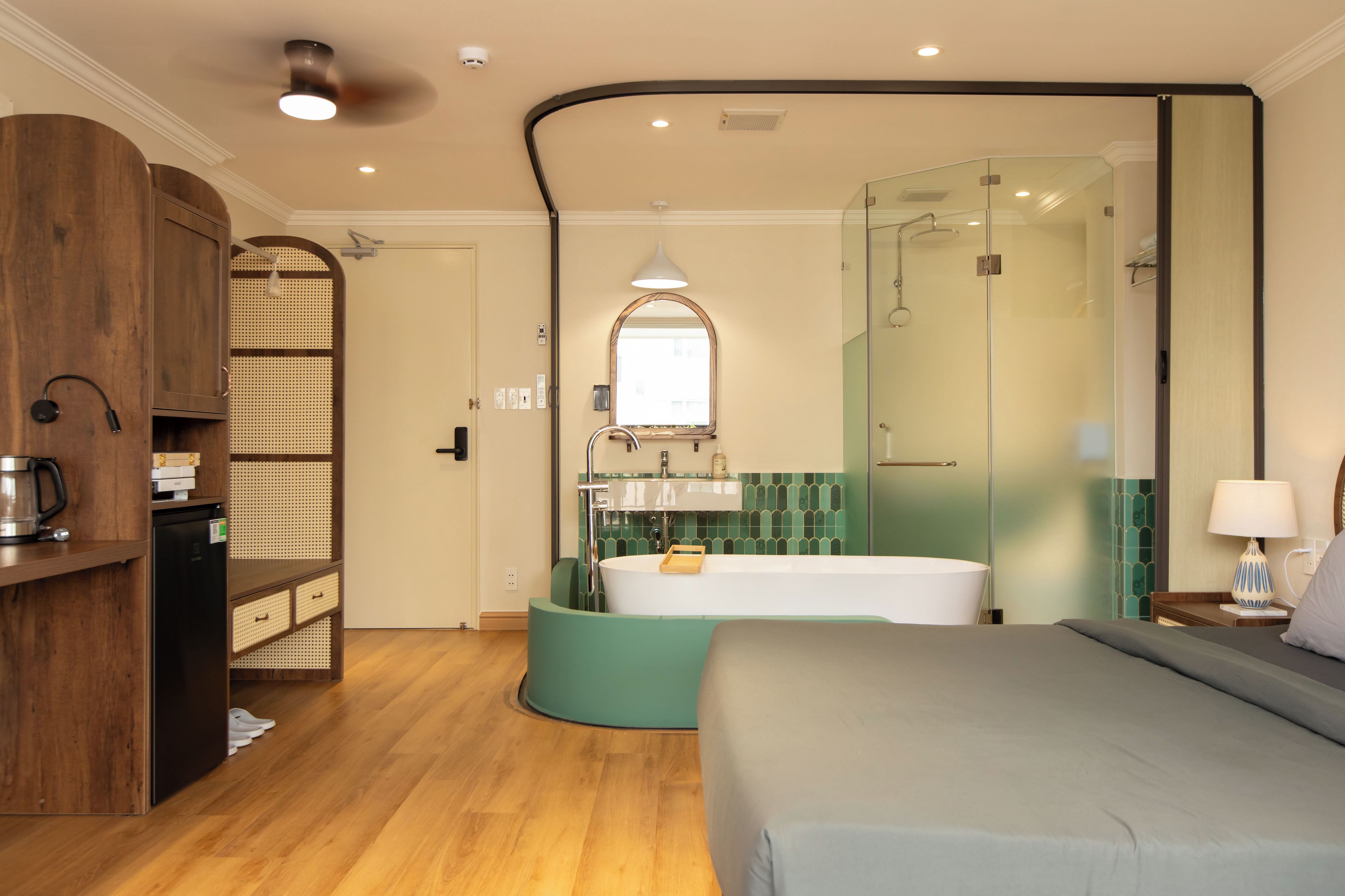 A modern bedroom with a bed, a built-in wardrobe, a shower, and a bathroom with a mirror.