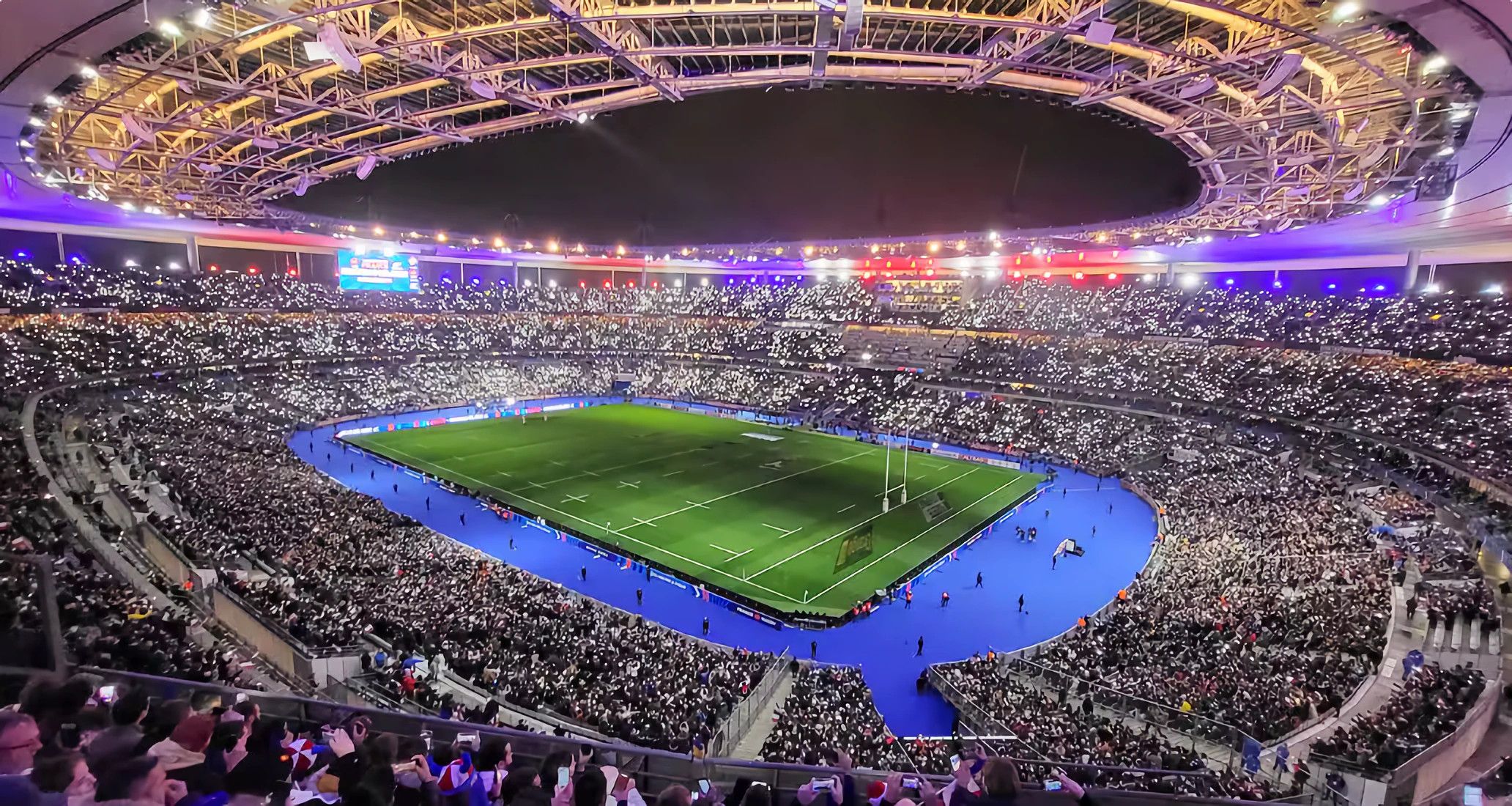 Een groot stadion met meerdere ringen van zitplaatsen en een middenveld.