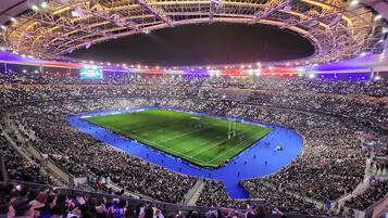Een groot stadion met meerdere ringen van zitplaatsen en een middenveld.
