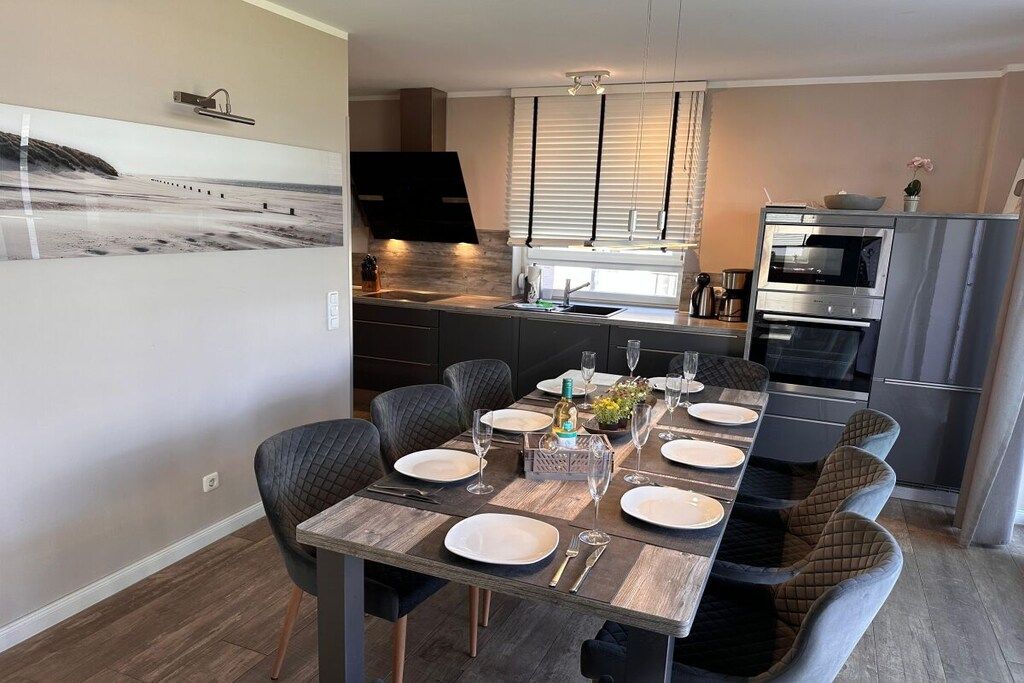 A modern kitchen with a dining area set for six.