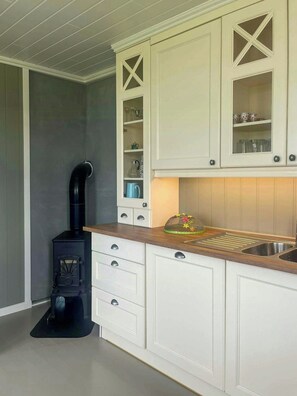 A kitchen with white cabinets, a black stove, and a sink.