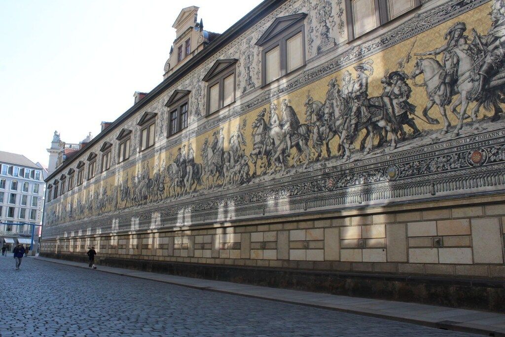 A building facade with a detailed mural depicting historical figures on horseback.