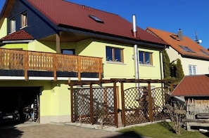 A two-story house with a balcony, a garage, and a fenced yard. - Holiday apartment with 1 bedroom (Bannewitz)