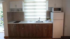 A kitchen with a built-in microwave, a sink, and cabinets. - Sofia Residence Apart Hotel (Çamyuva)
