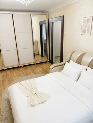 Una habitación de hotel con cama, armario y espejo.