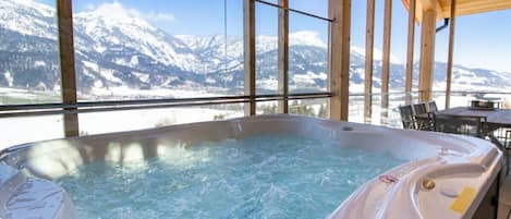 Ein Whirlpool mit Blick auf schneebedeckte Berge.