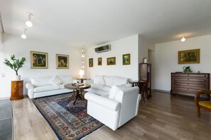 A modern living room with a white sofa set, a patterned rug, and a wooden cabinet. - Villa on Lake Como, Relax [Parking and WiFi] (Gera Lario)