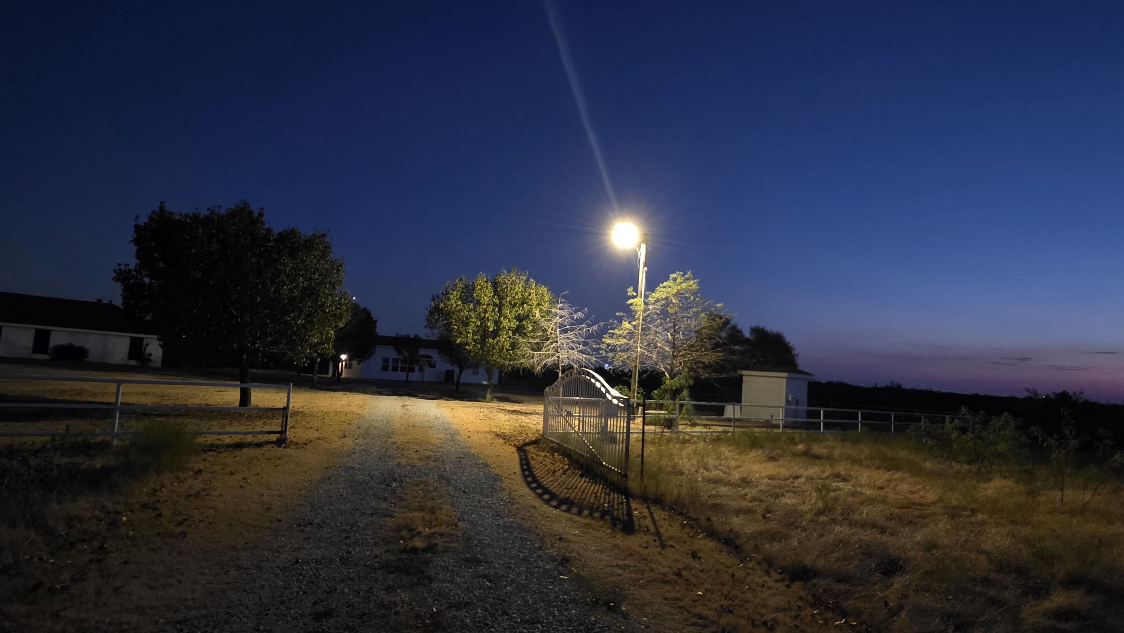 Sorapolkua, joka johtaa aidalla ja puilla ympäröityyn rakennukseen.
