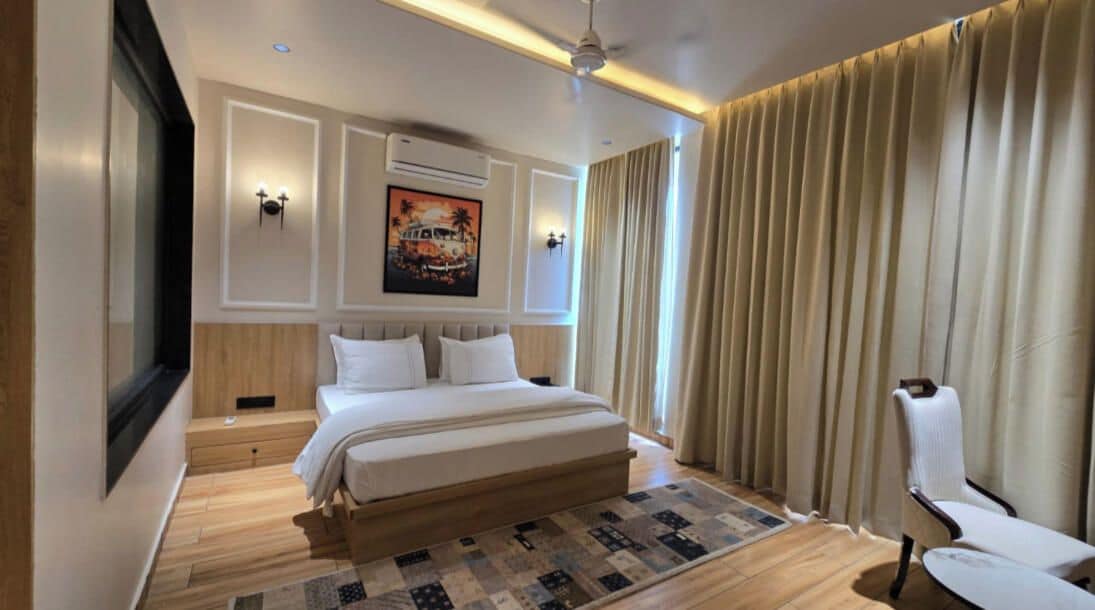 Habitación de hotel con una cama grande, un escritorio, una silla y un cuadro en la pared.