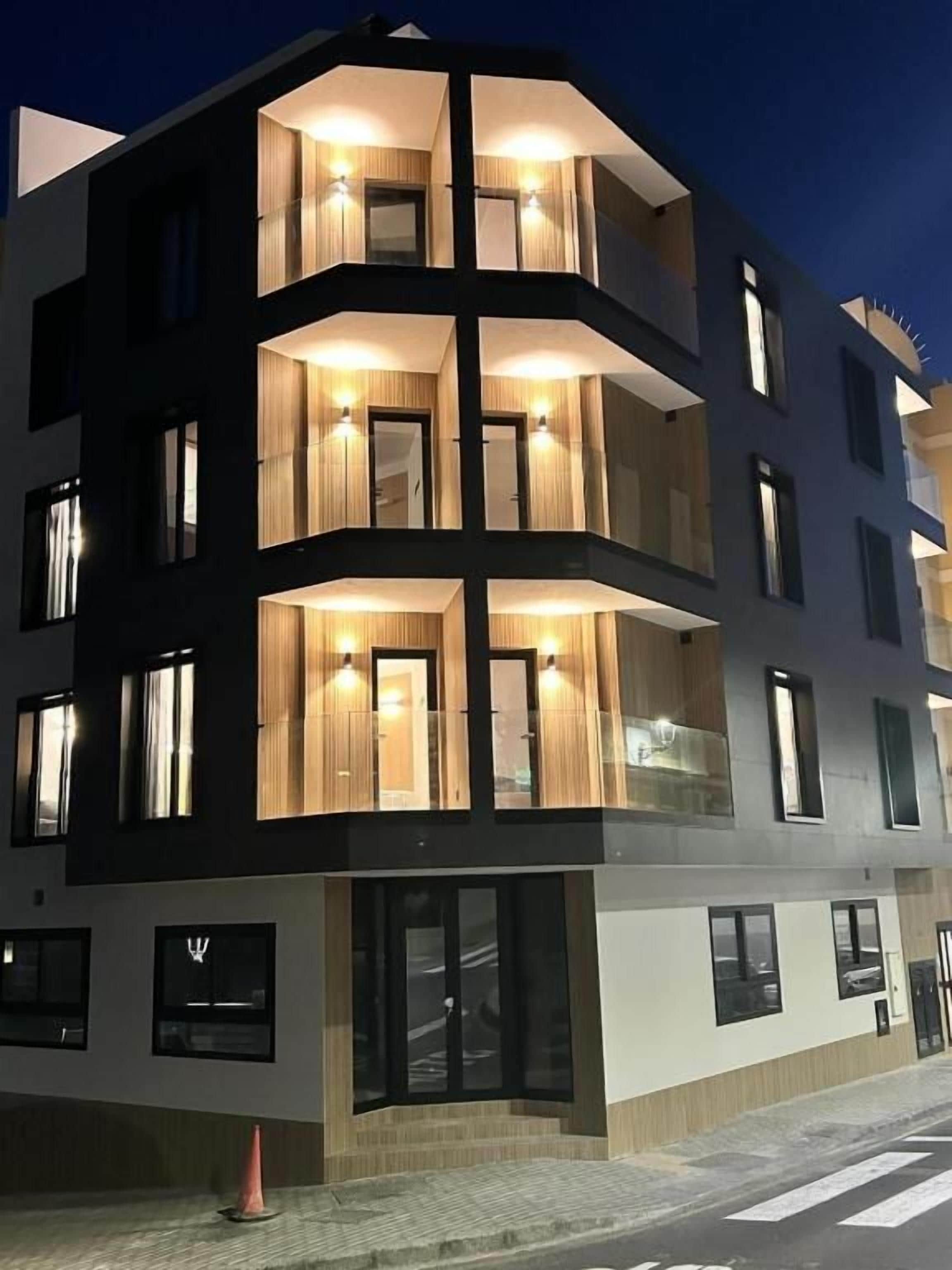 Un immeuble à plusieurs étages doté de balcons, de grandes fenêtres et d’une architecture moderne.
