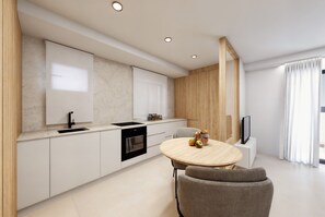 A modern kitchen with white cabinets, a black oven, and a wooden dining table with a chair.