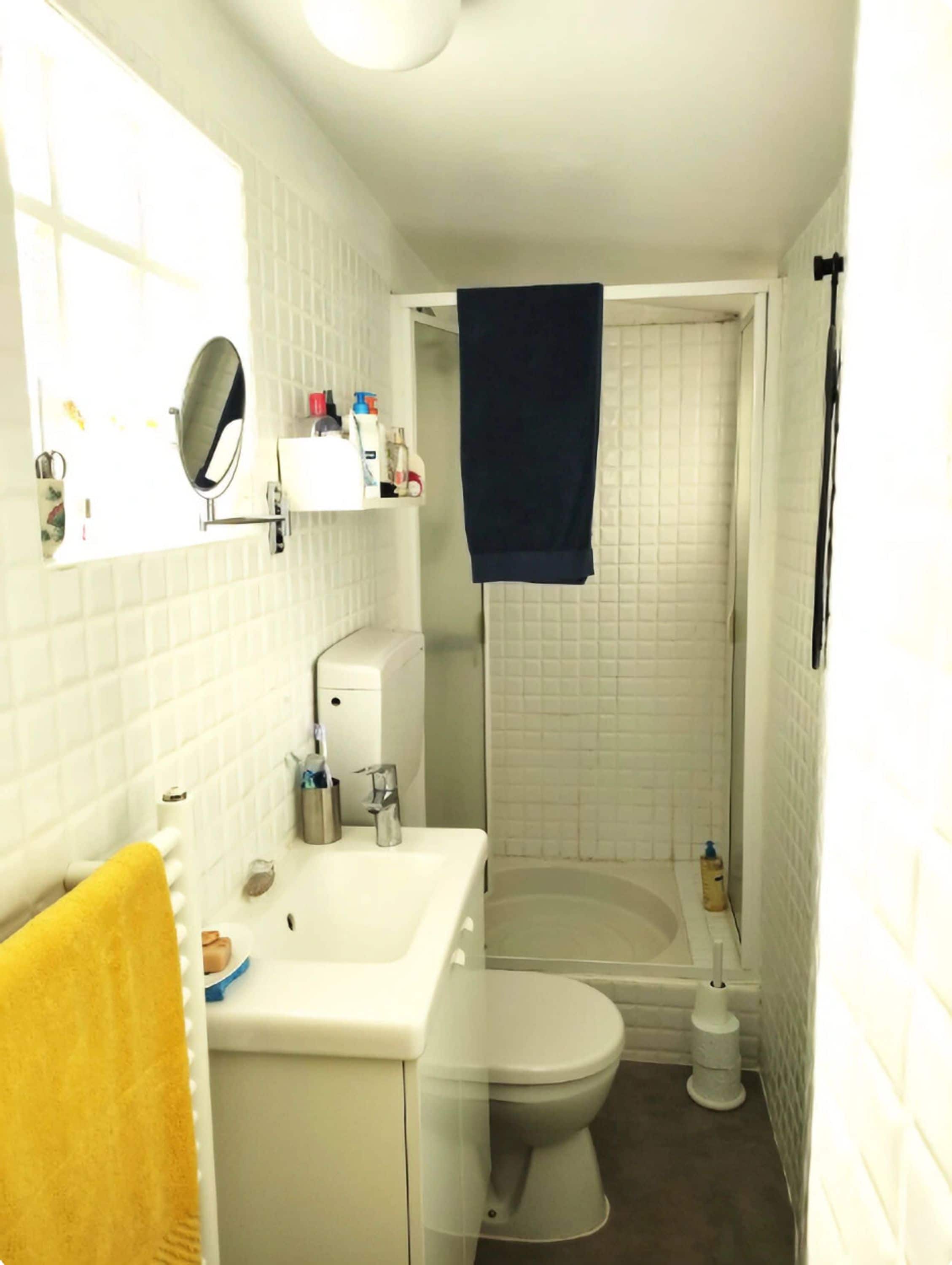 Een badkamer met een wit wastafelmeubel, spiegel en een wit toilet.