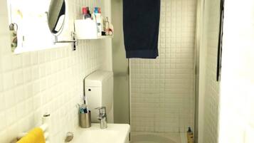 Een badkamer met een wit wastafelmeubel, spiegel en een wit toilet.