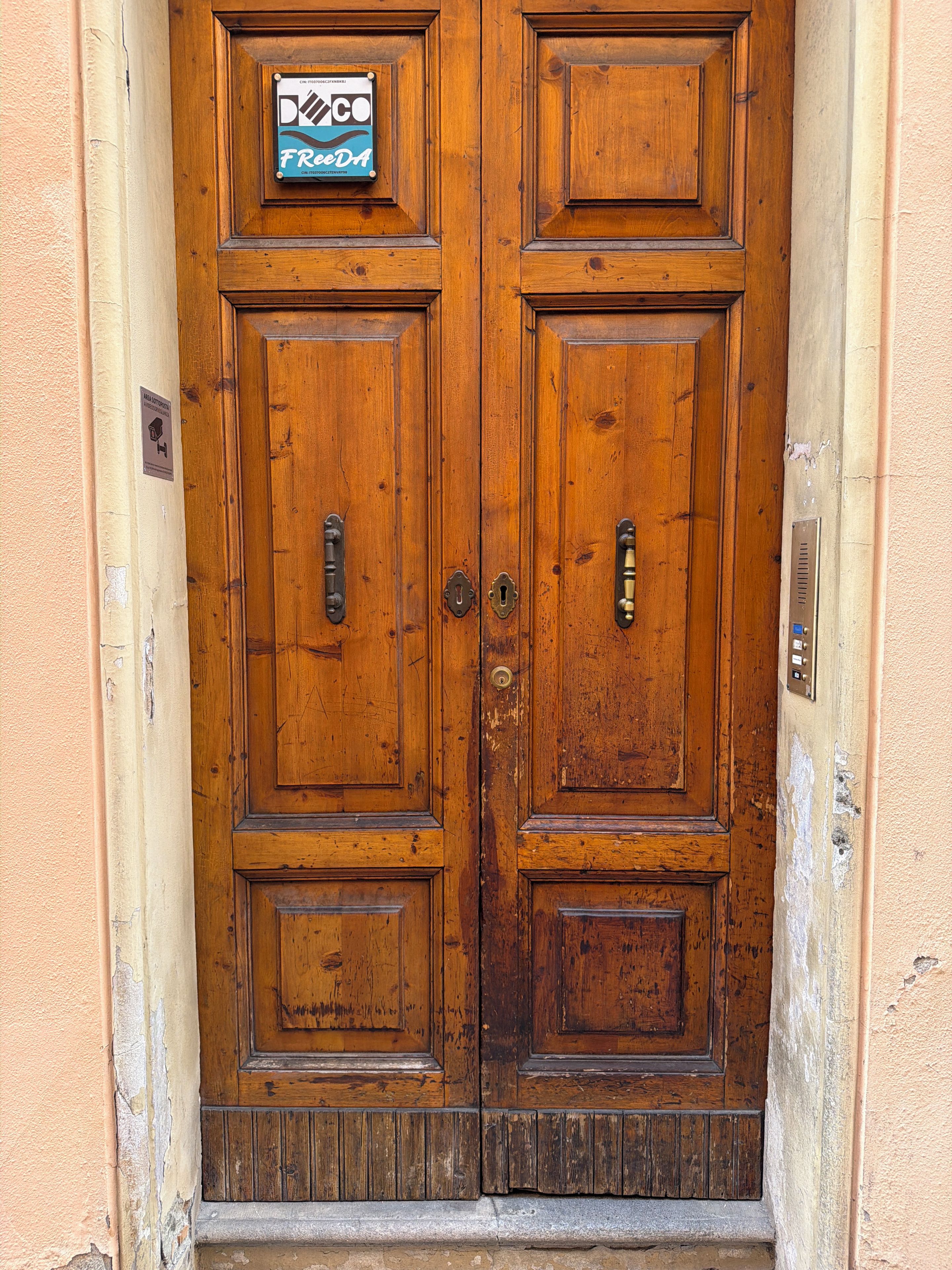 A wooden double door with a sign above it.